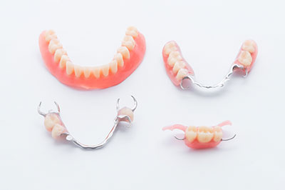 The image displays two pairs of dentures with a focus on the teeth, which are pink and white, placed against a plain background.